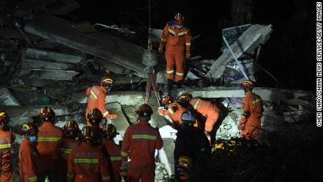 Firefighters search for survivors in the rubble of the collapsed canteen in a subdistrict office.