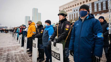 Local residents stand shoulder to shoulder with police officers at Sultan City Hall in Nur-Sultan on January 8.
