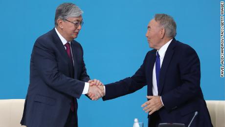 Kazakhstan&#39;s President Kassym-Jomart Tokayev (L) and former president Nursultan Nazarbaev shake hands at a party congress in 2019.