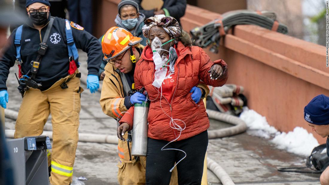 A woman is assisted by rescue personnel January 9.