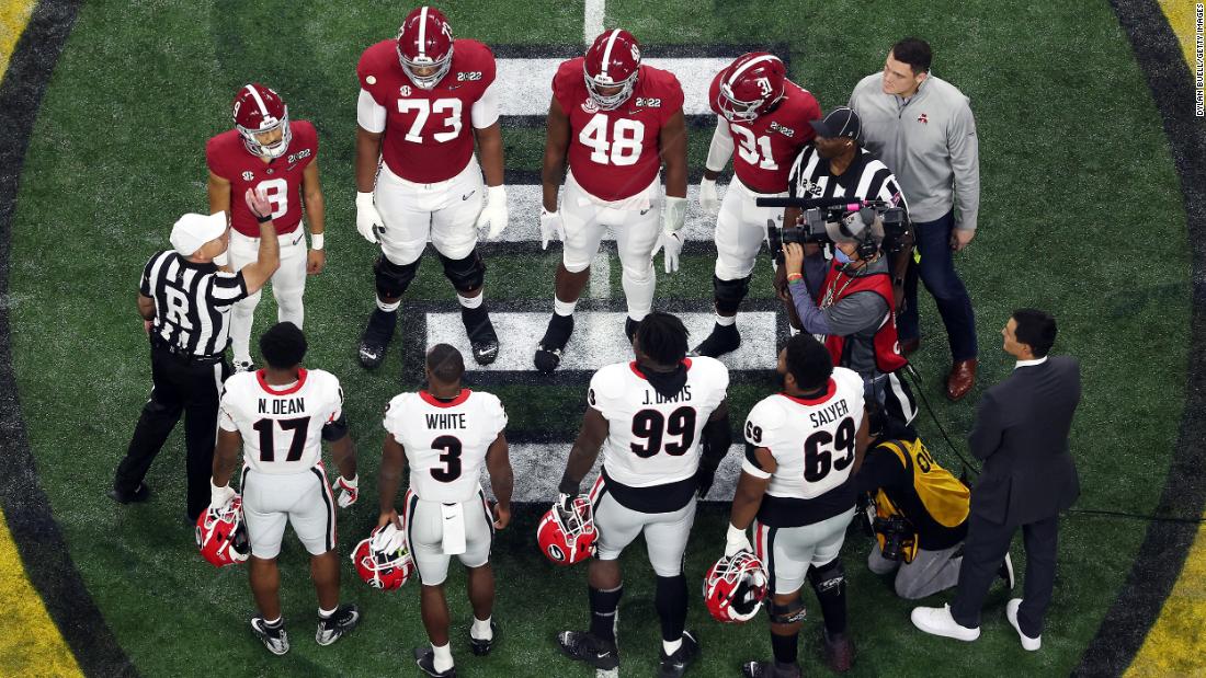 Team captains meet for the opening coin toss before kickoff.