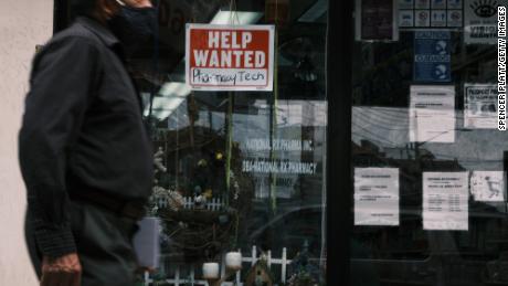 People walk by a Help Wanted sign in the Queens borough of New York City on June 04, 2021 in New York City. 