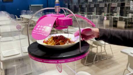 Early Olympics attendees eat noodles served from ceiling