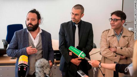 Pengacara Patrick Kroker, tengah, dan penggugat bersama Wassim Mukdad, kiri, dan Hussein Ghrer, kanan, menjawab wartawan'  pertanyaan di luar ruang sidang di Koblenz, Jerman, pada awal persidangan pada April 2020.