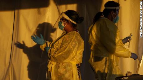 Healthcare workers are pictured at a drive-thru Covid-19 testing site in El Paso, Texas on January 12, 2022. - The country is currently seeing an average of 750,000 cases a day -- though that figure is soon expected to exceed a million -- around 150,000 total Covid hospitalizations, and more than 1,600 daily deaths. (Photo by PAUL RATJE / AFP) (Photo by PAUL RATJE/AFP via Getty Images)