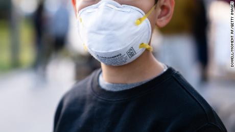 A boy wears an N95 face mask.