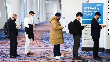 Attendees wear face masks as they wait in line for Covid-19 PCR testing for travel during the Consumer Electronics Show on January 7, 2022, in Las Vegas.