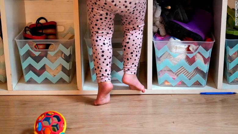 A preschooler gets up on her toes to reach into her cubby at a preschool center in Mountlake Terrace, Washington. 