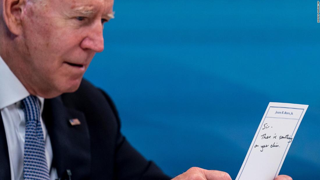 While hosting a virtual meeting with governors on July 30, Biden holds a card that read, &quot;Sir, there is something on your chin.&quot; &lt;br /&gt;&lt;br /&gt;An aide had handed Biden the card earlier in the meeting, and the President was using the other side of it to take notes. &lt;br /&gt;&lt;br /&gt;&quot;In Washington and with the seat of power, the smallest things can often times become big news, and this photograph of a lighthearted and minor gaffe quickly spread across news and social media,&quot; Associated Press photographer Andrew Harnik said.