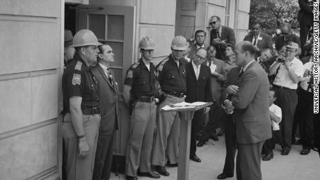 George Wallace was governor of Alabama for four terms between 1963 and 1987. In this photo he is attempting to block integration at the University of Alabama, standing defiantly at a door on June 11, 1963, while being confronted by US Deputy Attorney General Nicholas Katzenbach.
