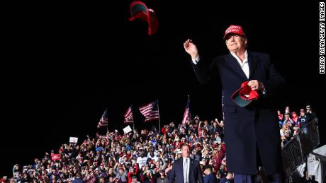 Voormalig president Donald Trump gooit een MAGA-hoed naar het publiek voordat hij spreekt tijdens een bijeenkomst op zaterdag 15 januari 2022 in Florence, Arizona.