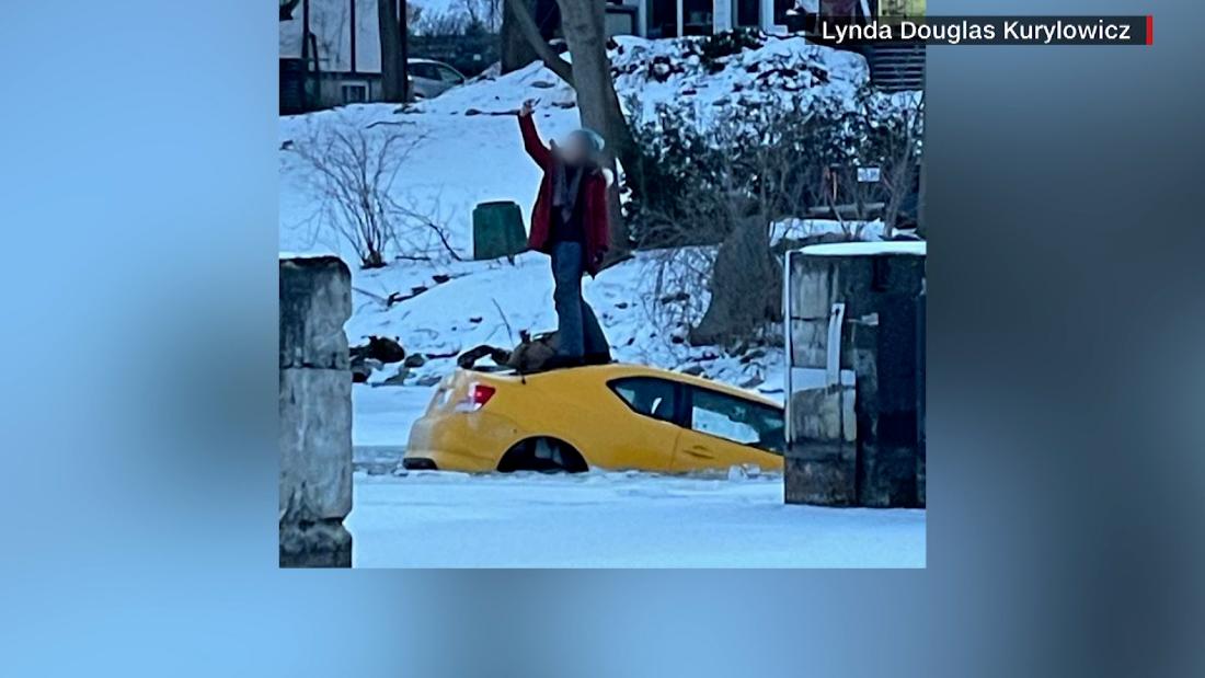 Woman takes selfie as car sinks down frozen river in Canada