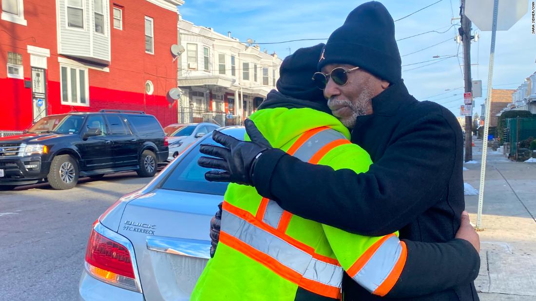 Larry Miller hugs Tyrone Kegler, great nephew of Edward White, at the same intersection where Miller committed murder. 