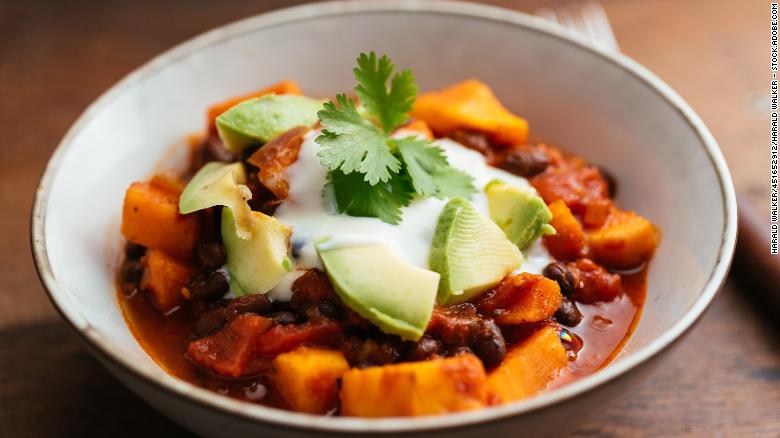 This vegan chili, made with sweet potatoes and black beans, is topped with soy yogurt and avocado.