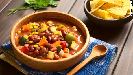 Prepare a vegetarian chili topped with a rainbow of diced vegetables and serve it with tortilla chips.