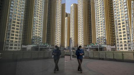 A pedestrian walks past apartment buildings at China Evergrande Group&#39;s City Plaza development in Beijing, China, on Friday, Dec. 10, 2021. 