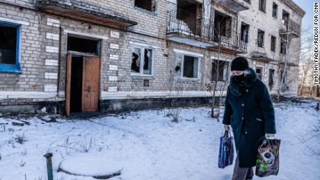 Local residents Marinka, Ukraine, walk past an apartment building destroyed during fighting in 2015 between the Ukrainian army and Russian-backed separatists. Fighting is still ongoing.