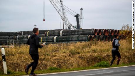 Biegacze mijają rury do gazociągu Nord Stream 2 w porcie Mukran w Sassnitz w Niemczech.