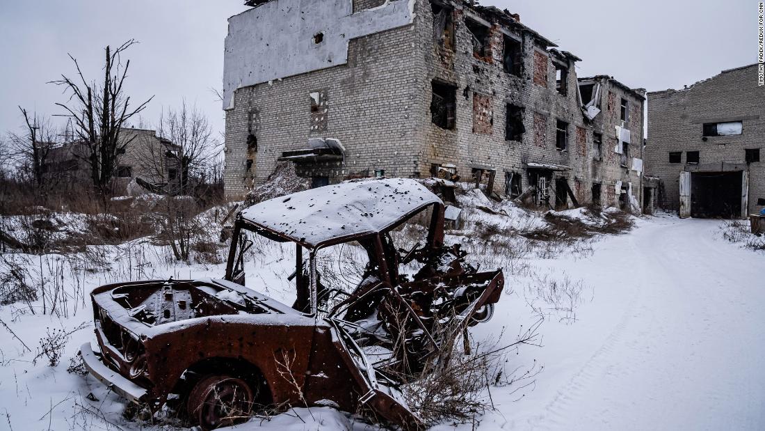 A destroyed car is seen outside a damaged building in Avdiivka.