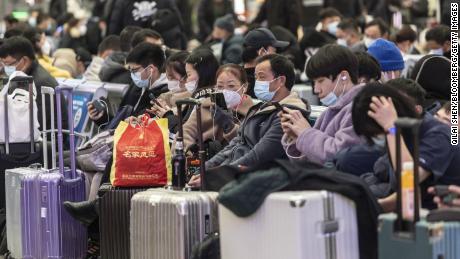 Travelers wearing protective masks wait in the main hall of the Hongqiao Railway Station ahead of Lunar New Year in Shanghai, China, on Sunday, Jan. 23, 2022. The Covid-19 outbreaks in multiple Chinese cities are pressuring travel demand ahead of the Lunar New Year holiday. Photographer: Qilai Shen/Bloomberg via Getty Images