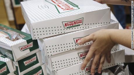 An employee carries boxes of doughnuts inside a Krispy Kreme Doughnuts Inc. store in the Times Square neighborhood of New York, on Sept. 10, 2020. 