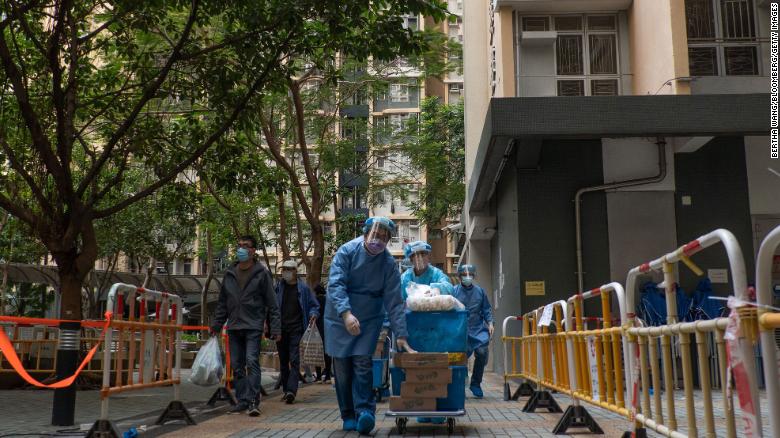 Health officials push a trolley of supplies outside a locked-down residential building in Hong Kong on January 23. 