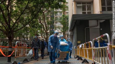 Health officials push a trolley of supplies outside a locked-down residential building in Hong Kong on January 23. 