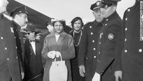 Autherine Lucy y Constance Baker Motley caminan a través de una línea de policía después de que Lucy fuera expulsada de la Universidad de Alabama el 1 de marzo de 1956, donde fue la primera estudiante negra de la escuela.