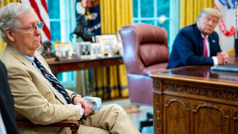 McConnell listens as then-President Donald Trump talks to reporters while hosting Republican congressional leaders and members of Trump&#39;s cabinet in the Oval Office at the White House in July 2020 in Washington, DC. 