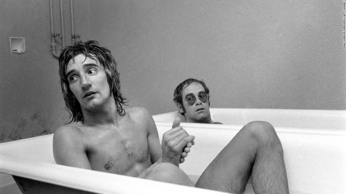 John and singer Rod Stewart have a bath at the stadium of Watford Football Club in 1973. John, a lifelong Watford fan, later owned the English soccer club. Today, one of the stadium&#39;s stands is named after him.