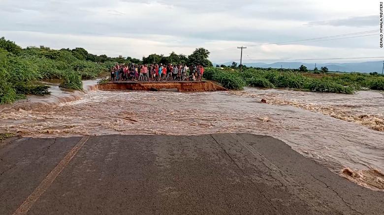 People stand on the other side of a road destroyed by tropical storm Ana, along M1 Chikwawa road, Malawi. 