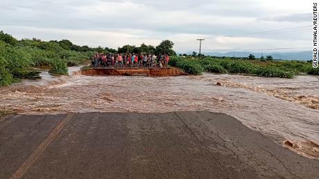 Las personas se paran al otro lado de una carretera devastada por la tormenta tropical Anna, a lo largo de M1 Chikwawa, Malawi. 