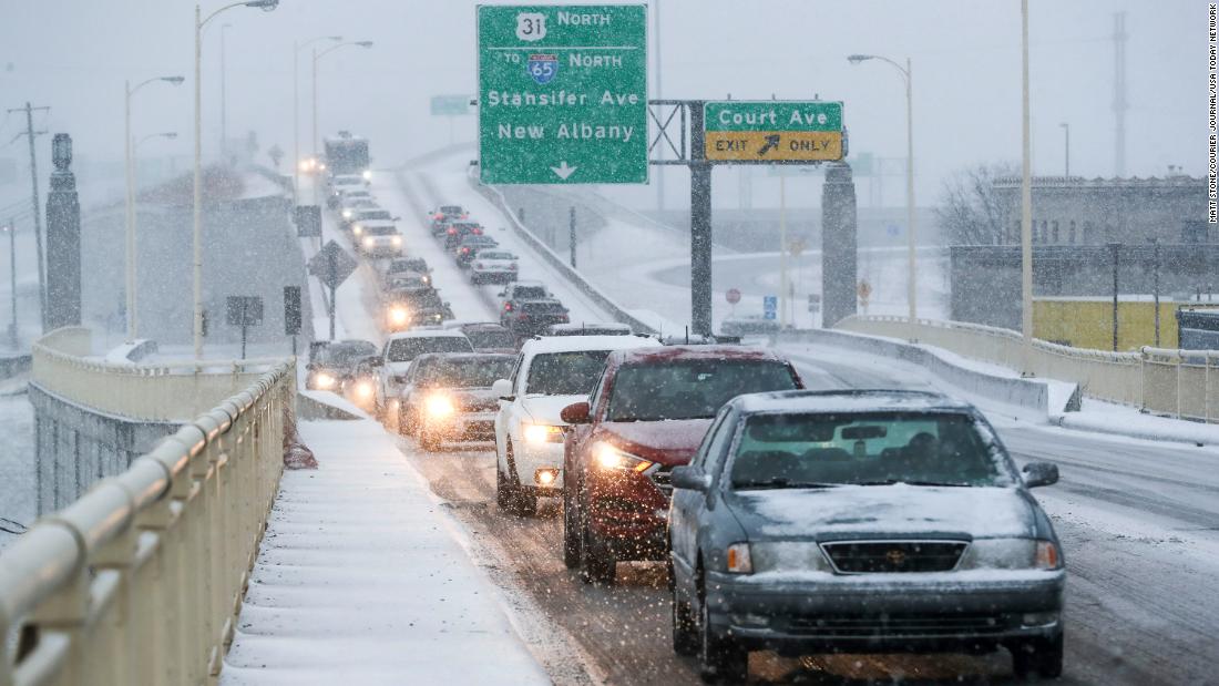 Slow traffic travels in the snow on Friday, in Louisville, Kentucky.