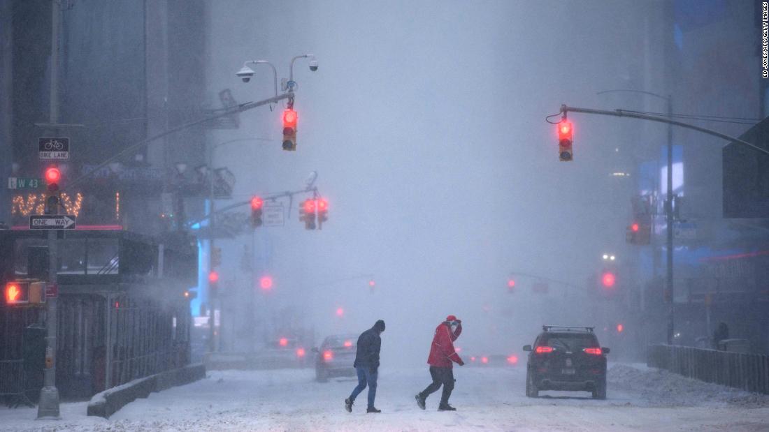 Pedestrians and motorists make their way through heavy snow in Times Square in New York on Saturday.