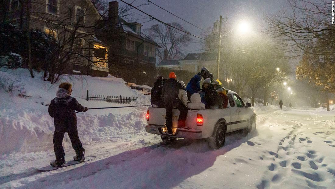 A person snowboards while pulled from a pickup truck in Providence, Rhode Island, on Saturday.