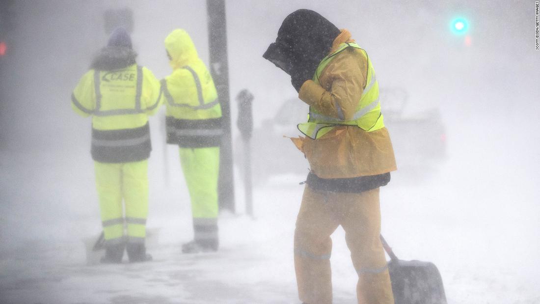 A worker shields himself from blowing snow in Boston, Massachusetts, on Saturday, January 29. 