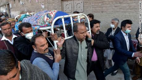 Christian devotees carry the coffin of a priest who was gunned down when driving back home after Sunday prayers in Peshawar on January 30, 2022.