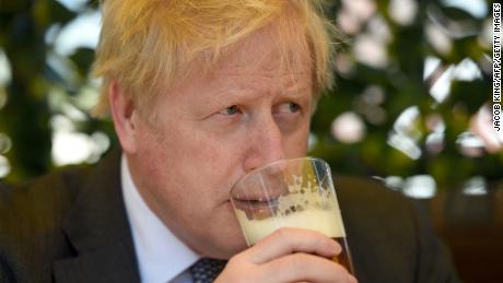 Boris Johnson sips a pint of beer at a pub in Wolverhampton, central England, April 19, 2021.