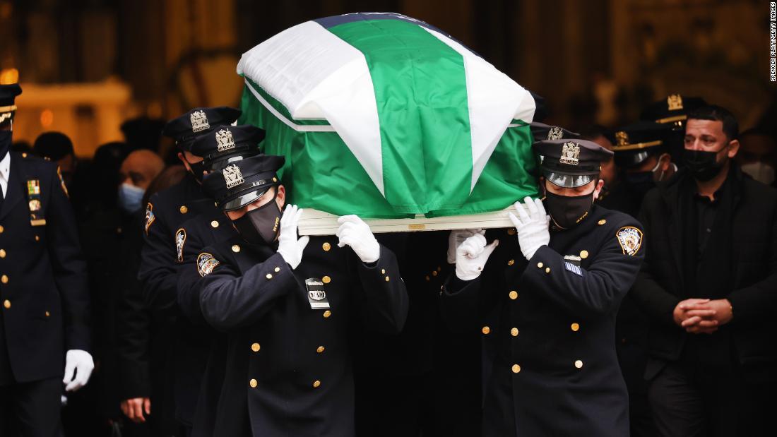 The casket of New York City police officer Wilbert Mora is carried out of St. Patrick&#39;s Cathedral on Wednesday, February 2. The flag over his casket is t he flag of the New York Police Department.