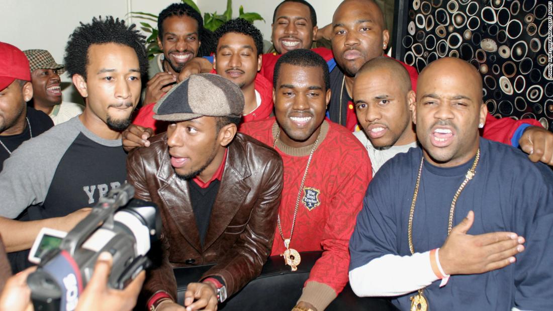West, at center in red, hangs out with some famous friends in the music industry, including John Legend, Mos Def, Consequence and Damon Dash, after a performance in New York in 2003. West&#39;s first studio album, &quot;The College Dropout,&quot; released in February 2004.