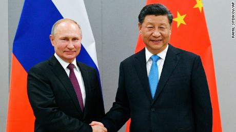 Russian President Vladimir Putin and China&#39;s President Xi Jinping shake hands at the BRICS Summit in Brazil in November, 2019. 