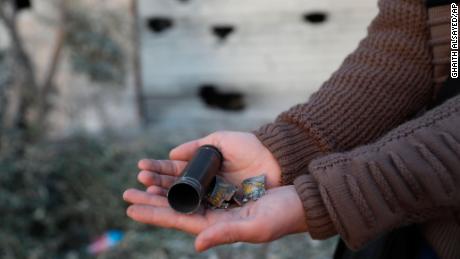A child shows an empty bullet shell after the raid in Atmeh.