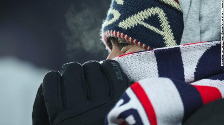 A fan tries to stay warm during the match.