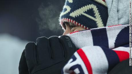 A fan tries to stay warm during the match.