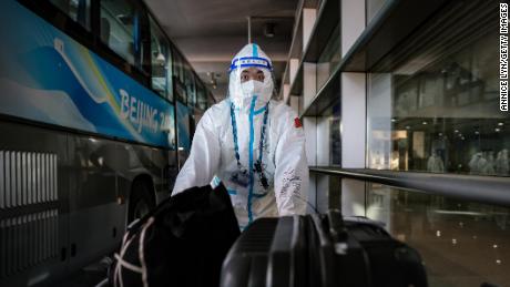 An Olympic worker wheels suitcases onto a media transportation bus at the Beijing airport on February 2, ahead of the Winter Olympics.