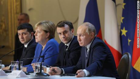 Ukrainian President Volodymyr Zelensky, then-German Chancellor Angela Merkel, Macron and Putin give a press conference after a summit on Ukraine at the Elysee Palace in Paris on December 9, 2019. 