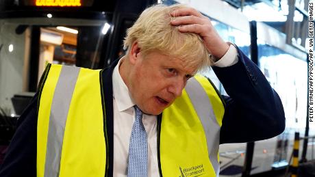Britain's Prime Minister Boris Johnson gestures as he speaks to members of the media during a visit the Blackpool Transport Depot in north-west England on February 3, 2022. 