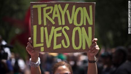 A woman holds a sign as she attends a rally honoring Trayvon Martin organized by the National Action Network outside One Police Plaza in Manhattan on July 20, 2013 in New York City.  