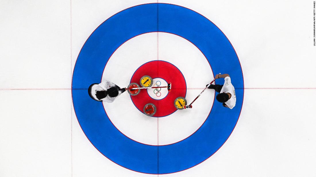 Chinese curlers Fan Suyuan, left, and Ling Zhi strategize while competing in a mixed-doubles match against Great Britain on February 6.