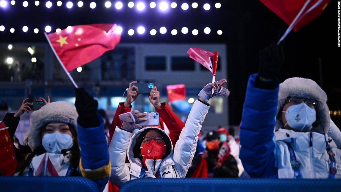 Volunteers wave flags during a medal ceremony on February 7.